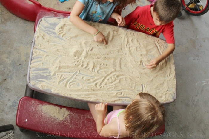 Make a sand table for storytelling, letter formation, and drawing. Kids love this outdoor play idea!