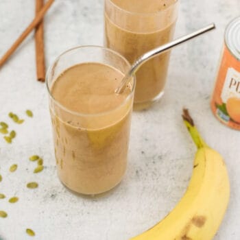 pumpkin spice latte smoothies in two glasses with a banana